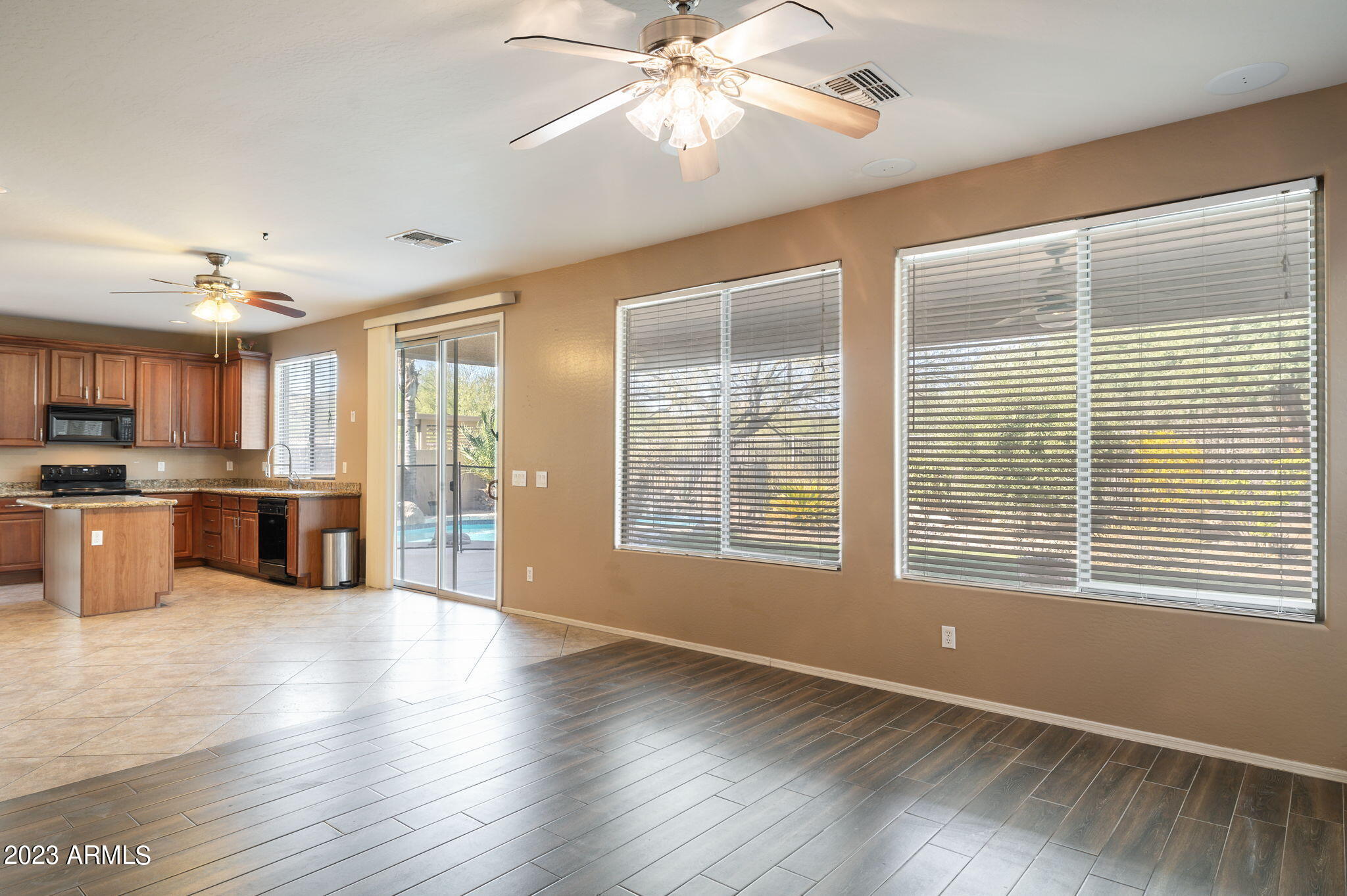 3344 West Montello Road Phoenix, AZ 85086 - Photo 5 of 38 a view of an empty room with window wooden floor and a kitchen