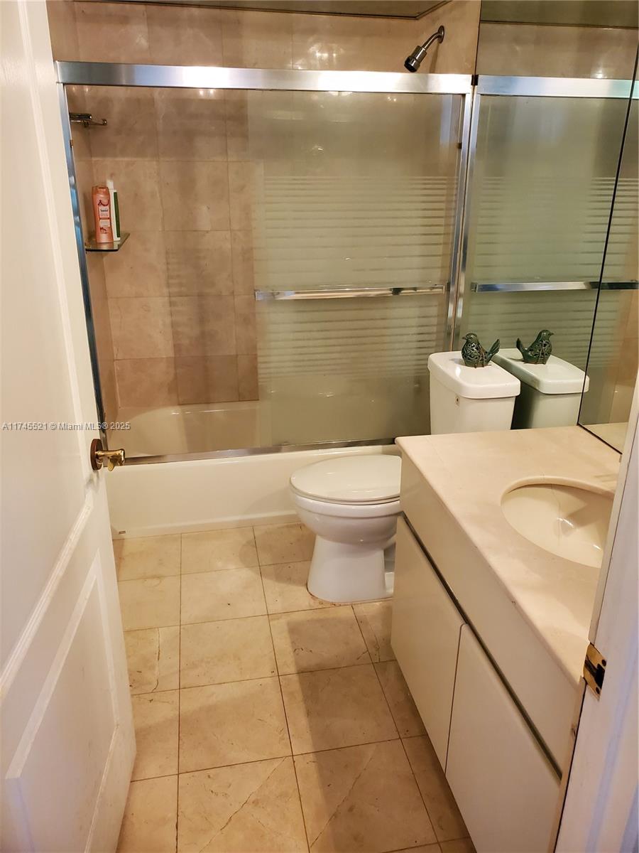 5757 Collins Avenue, Unit 1902 Miami Beach, FL 33140 - Photo 19 of 25 a bathroom with a sink a toilet and shower