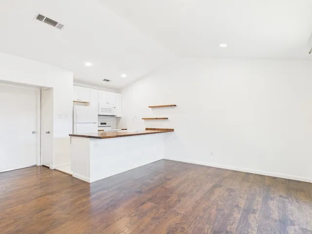 a room with kitchen island a sink cabinets and wooden floor