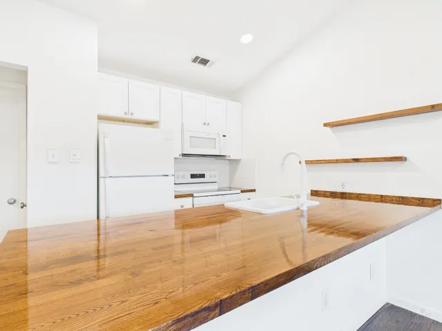 a kitchen with granite countertop a sink and a refrigerator
