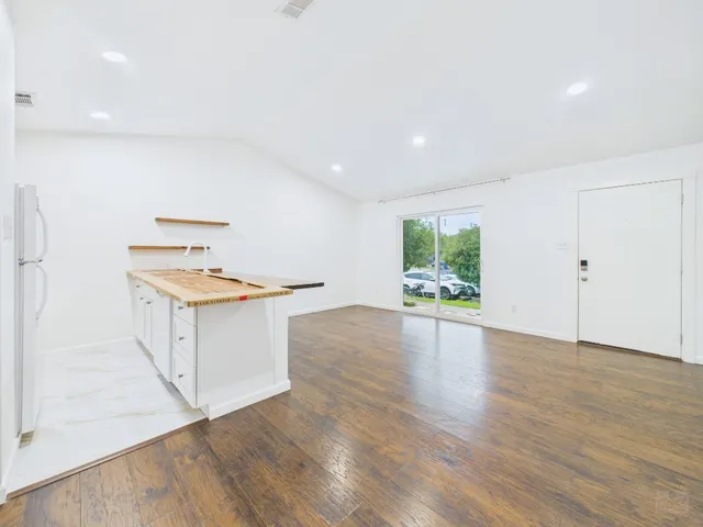 a kitchen with cabinets and wooden floor