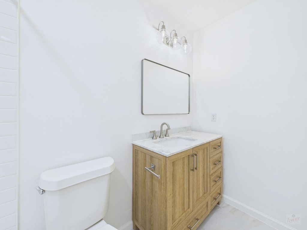1303 Hollow Creek Drive, Unit 1 Austin, TX 78704 - Photo 10 of 19 a bathroom with a toilet a sink and mirror