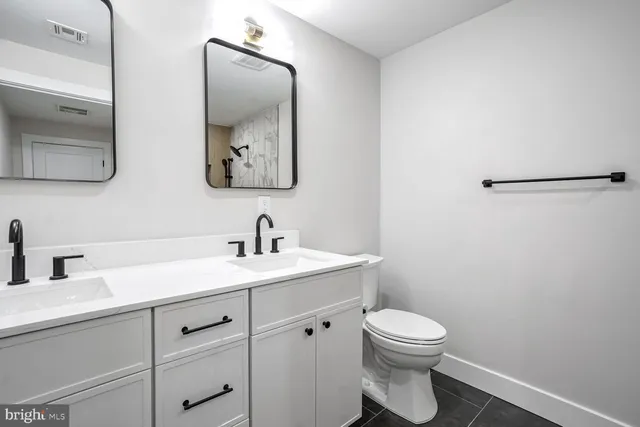 a bathroom with a toilet a sink and mirror