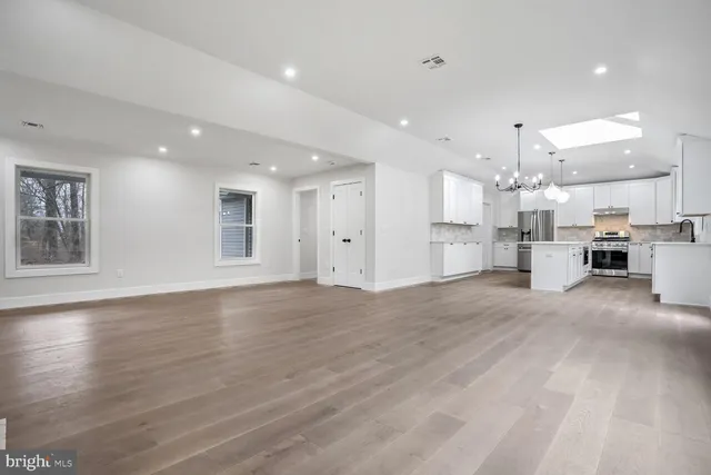 a view of kitchen with kitchen island white cabinets and wooden floor