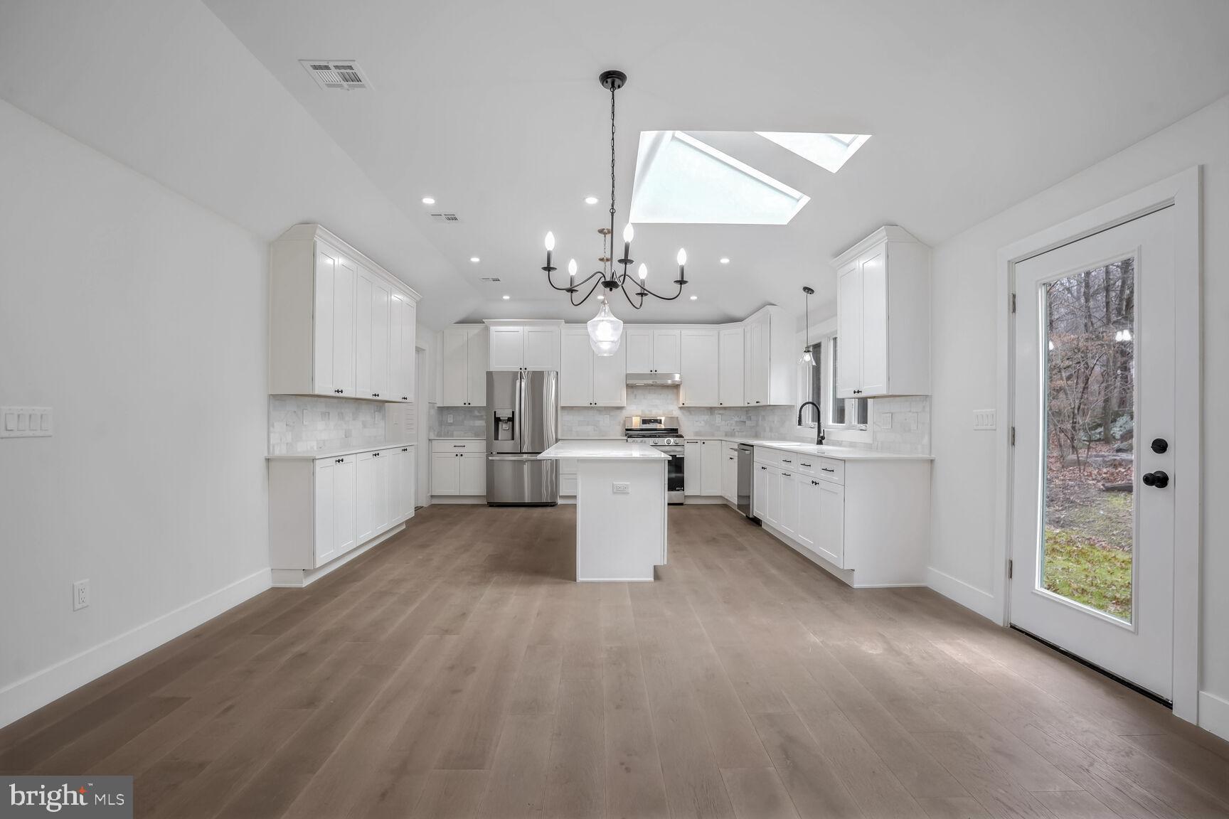 358 A Cherry Valley Road Princeton, NJ 08540 - Photo 6 of 28 a large white kitchen with a large window a sink and stainless steel appliances