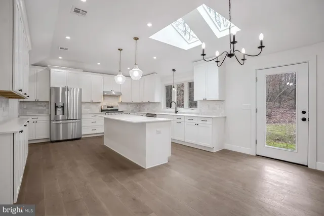 a view of a kitchen with a sink and refrigerator