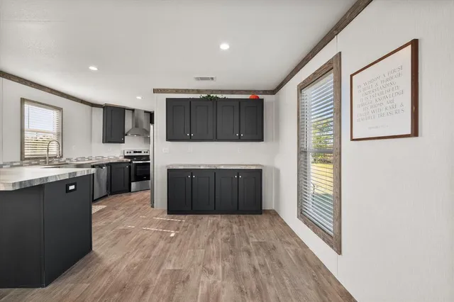 a large kitchen with stainless steel appliances granite countertop a stove a sink and a refrigerator