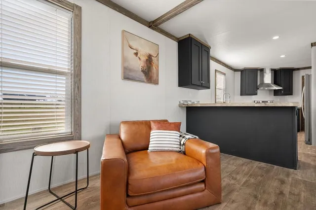 a work place with stainless steel appliances kitchen island granite countertop furniture a rug and a window