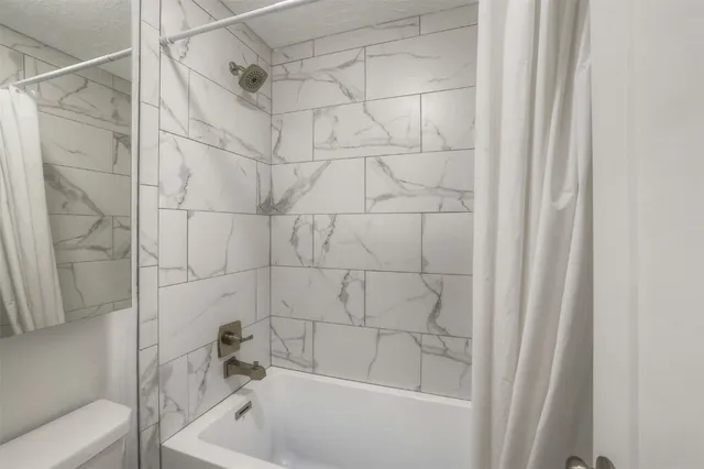 a bathroom with a shower and a bath tub