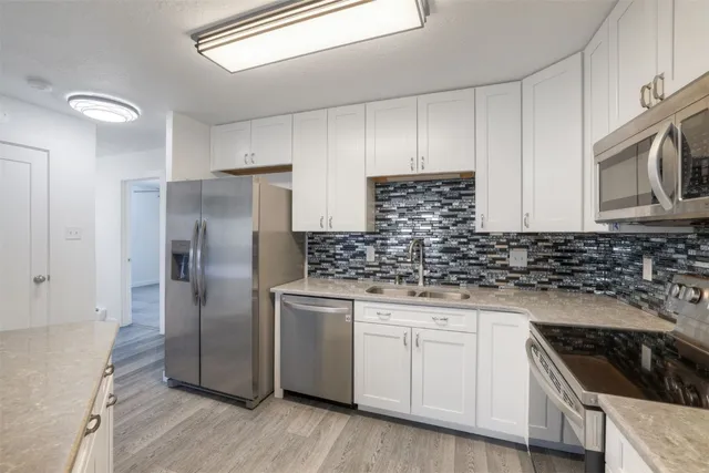 a kitchen with granite countertop a sink and steel stainless steel appliances