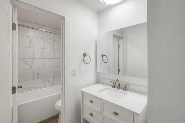 a bathroom with a bathtub a sink a toilet and a mirror