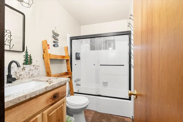 a bathroom with a sink and mirror with bathtub