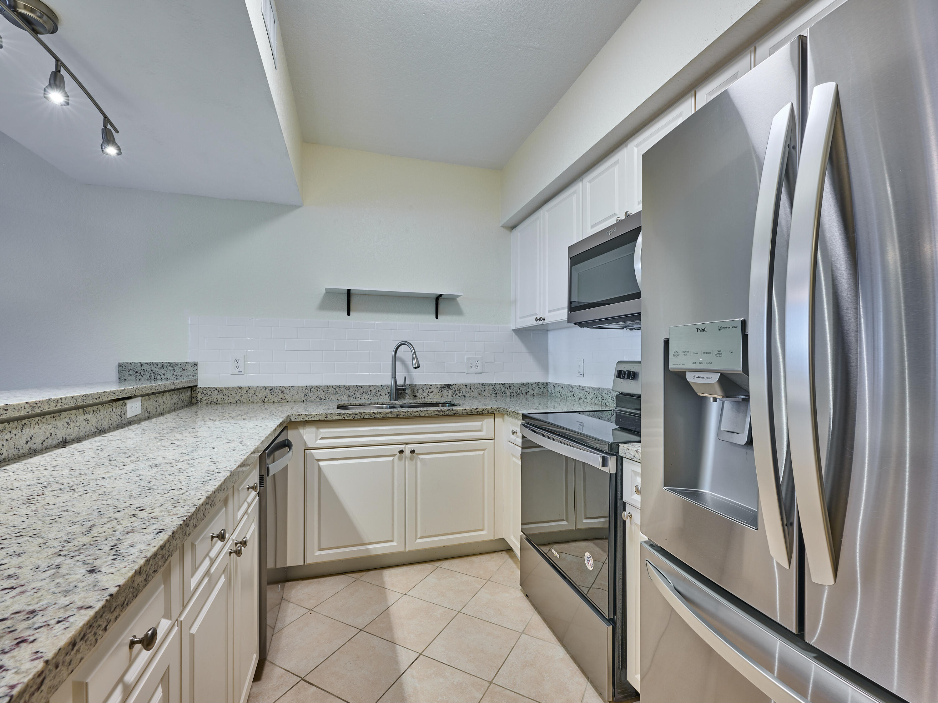 6344 West Sample Road, Unit 6344 Coral Springs, FL 33067 - Photo 12 of 30 a kitchen with stainless steel appliances granite countertop a sink stove and refrigerator