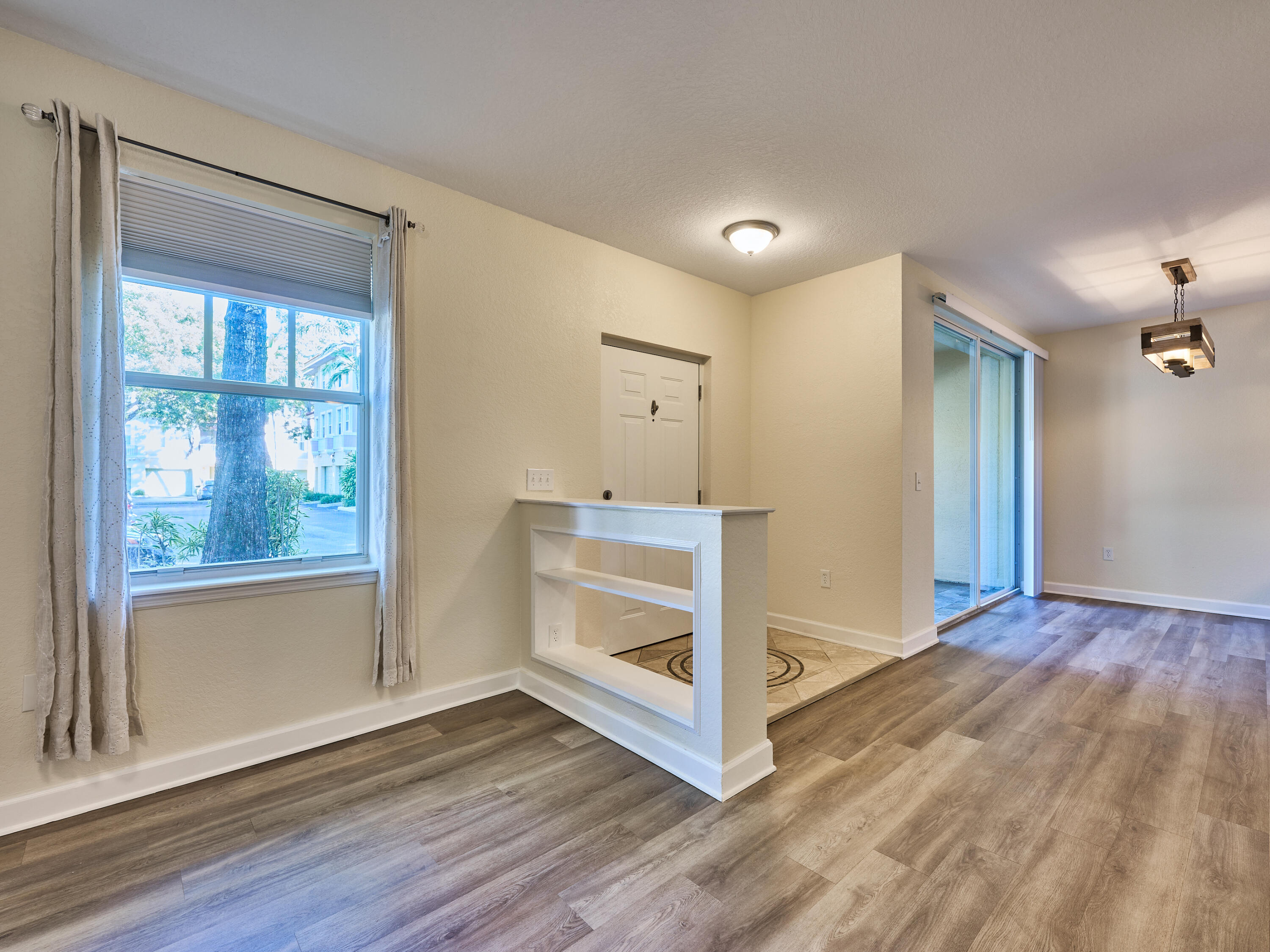 6344 West Sample Road, Unit 6344 Coral Springs, FL 33067 - Photo 4 of 30 a view of an empty room with wooden floor and a window