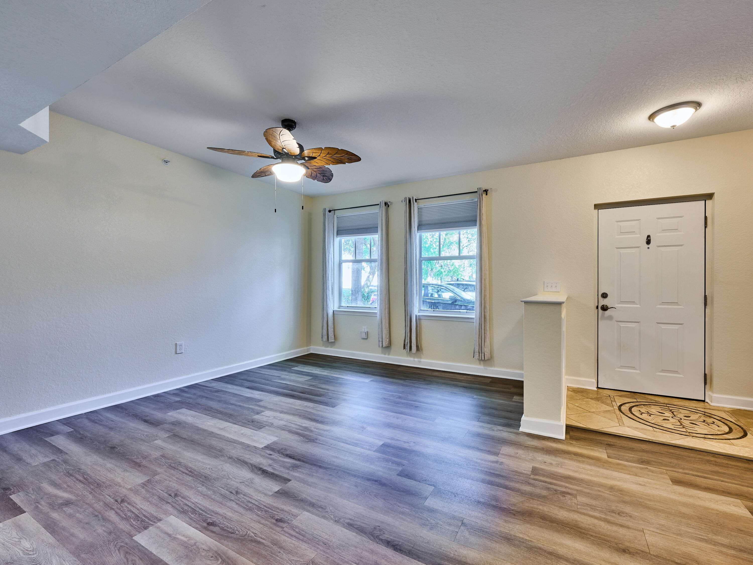 6344 West Sample Road, Unit 6344 Coral Springs, FL 33067 - Photo 5 of 30 an empty room with wooden floor chandelier fan and windows