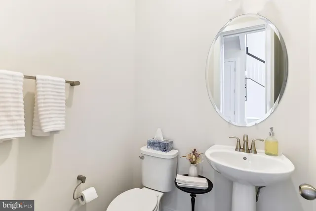 a bathroom with a toilet a sink and mirror
