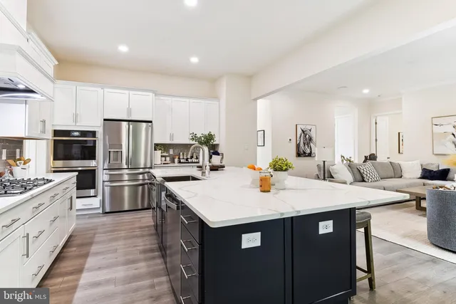 a large kitchen with a center island and stainless steel appliances