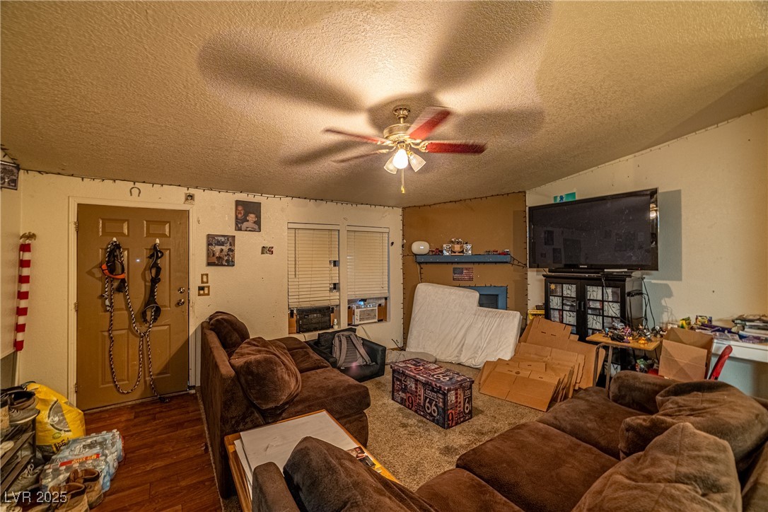 4231 West Wilson Road Pahrump, NV 89048 - Photo 3 of 15 Living area with wood finished floors, a textured ceiling, and ceiling fan