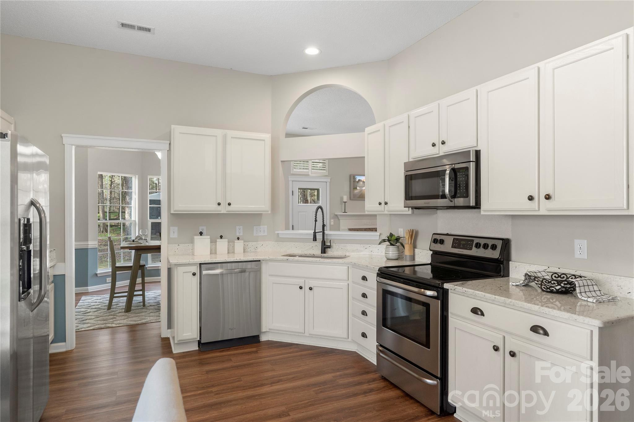 12028 Regent Ridge Lane Charlotte, NC 28278 - Photo 13 of 42 a kitchen with stainless steel appliances a stove a sink a refrigerator and white cabinets
