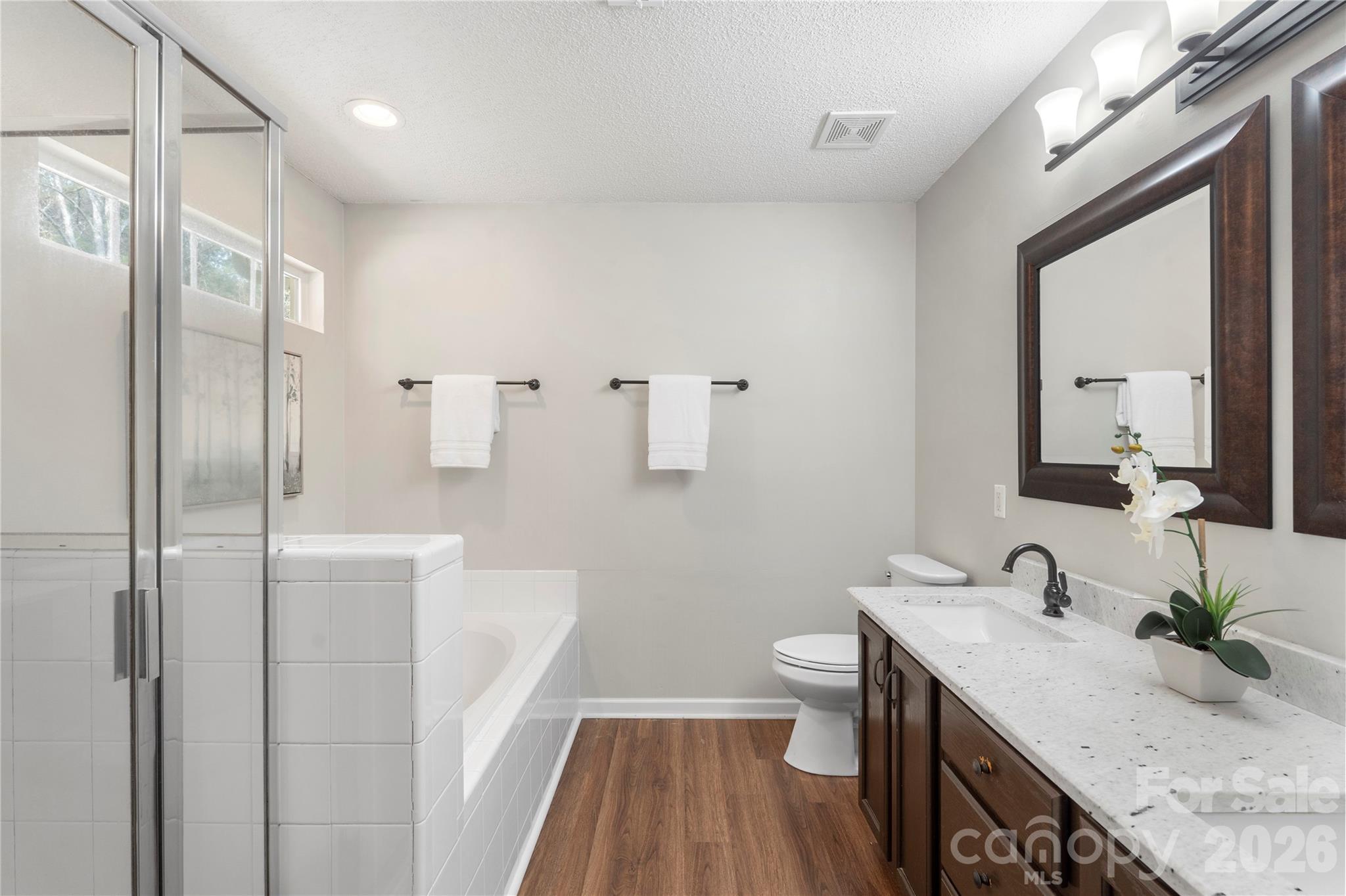 12028 Regent Ridge Lane Charlotte, NC 28278 - Photo 22 of 42 a bathroom with a granite countertop sink a toilet a mirror and shower