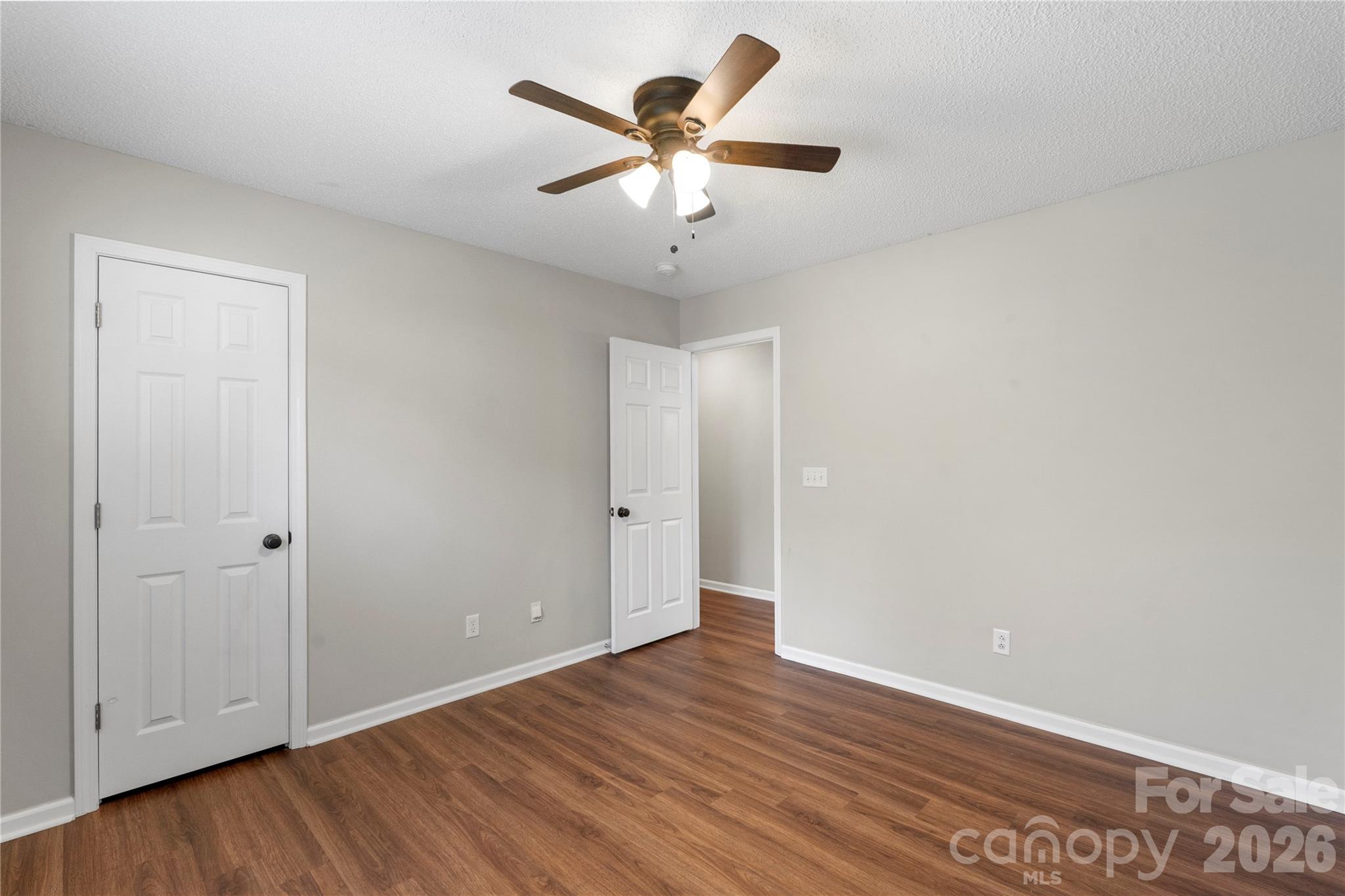12028 Regent Ridge Lane Charlotte, NC 28278 - Photo 26 of 42 an empty room with wooden floor and ceiling fan
