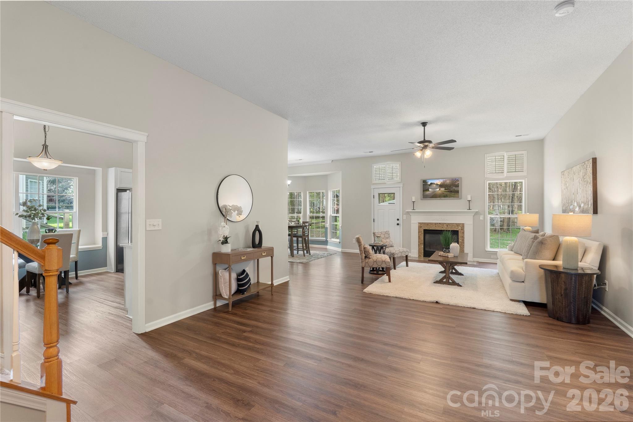 12028 Regent Ridge Lane Charlotte, NC 28278 - Photo 4 of 42 a living room with furniture dining table a fireplace and a large window
