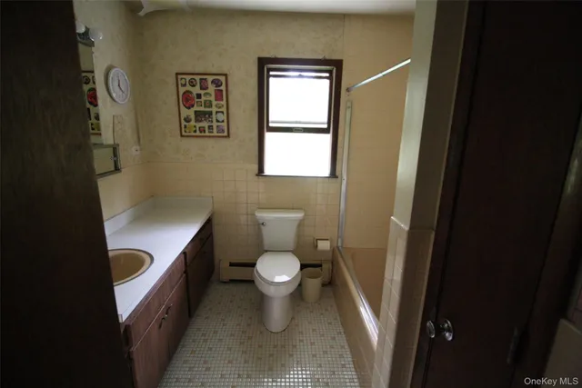 a bathroom with a granite countertop toilet and a sink
