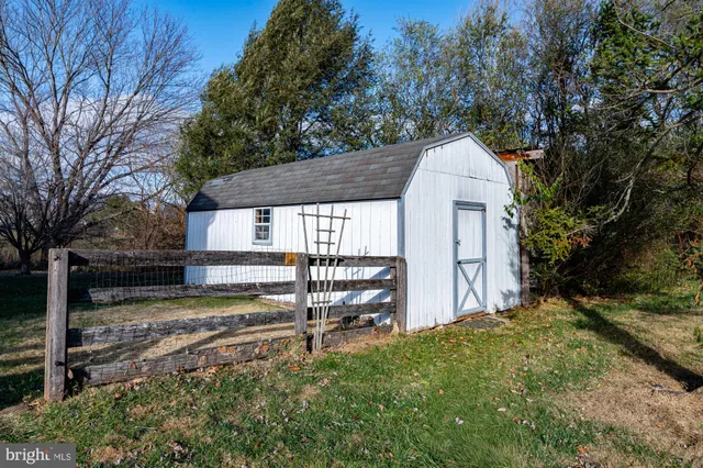 a view of dirt field with large trees