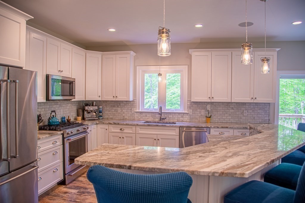 46 True Road Salisbury, MA 01952 - Photo 11 of 25 a kitchen with kitchen island granite countertop a sink a counter top space appliances and cabinets