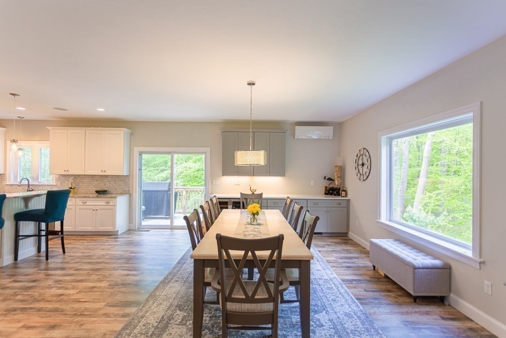 46 True Road Salisbury, MA 01952 - Photo 7 of 25 a dining room with wooden floor a chandelier a wooden table and chairs