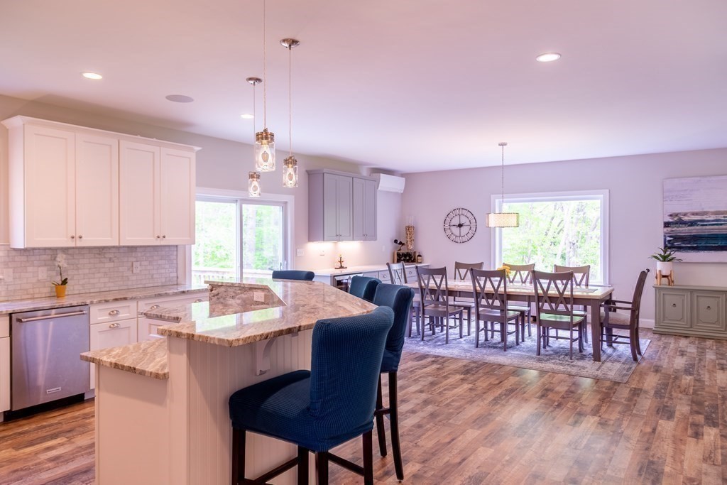 46 True Road Salisbury, MA 01952 - Photo 9 of 25 a dinning area with granite countertop a stove a sink a dining table and chairs with wooden floor