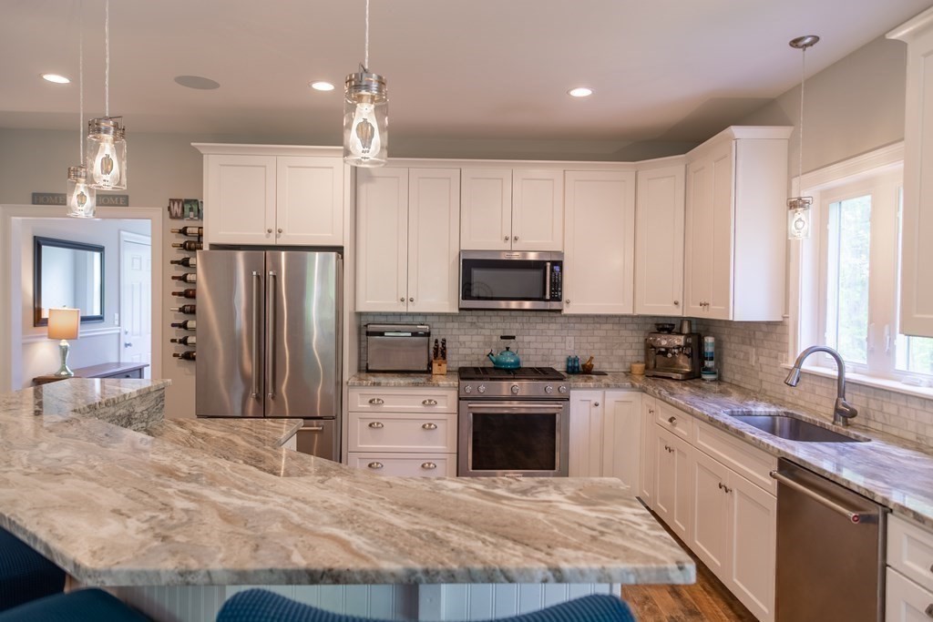 46 True Road Salisbury, MA 01952 - Photo 10 of 25 a kitchen with stainless steel appliances granite countertop a stove top oven a sink dishwasher and a refrigerator with wooden floor