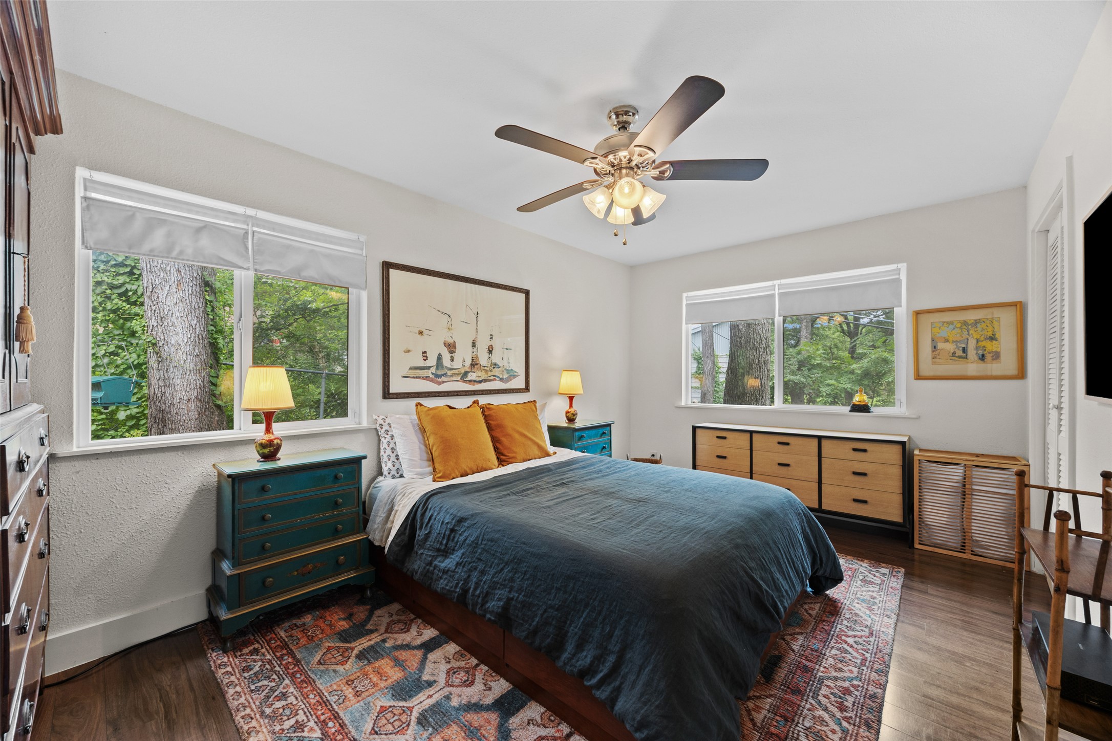 3302 Cherrywood Road Austin, TX 78722 - Photo 14 of 26 Primary bedroom showcases rich hardwood and peaceful views. Surrounded by trees on all sides there is plenty of peace and privacy.