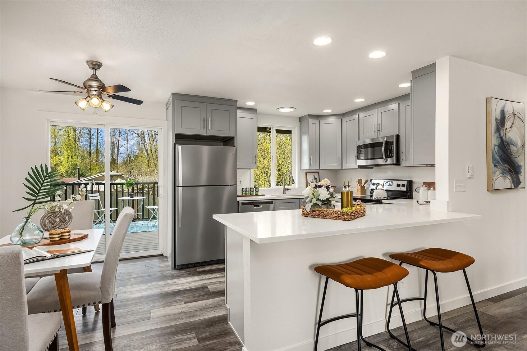 2208 182nd Street Southeast Bothell, WA 98012 - Photo 21 of 24 a kitchen with stainless steel appliances granite countertop a refrigerator a stove a sink a dining table and chairs with wooden floor