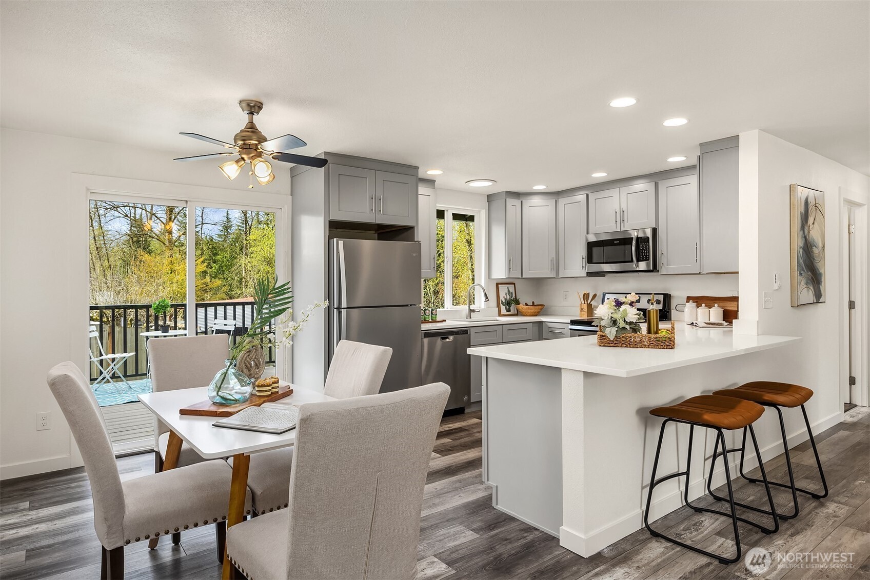 2208 182nd Street Southeast Bothell, WA 98012 - Photo 6 of 24 a dining room with kitchen island stainless steel appliances furniture a chandelier and a view of kitchen