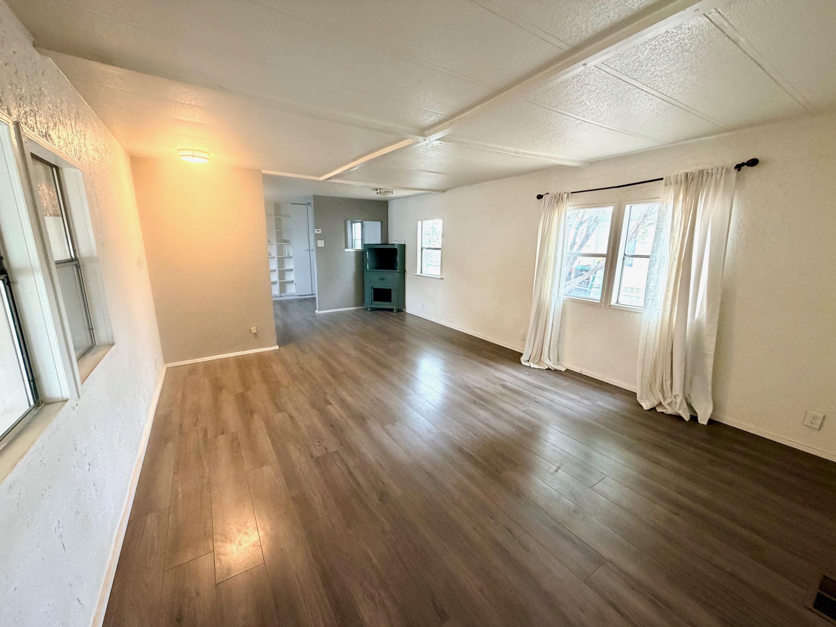 585-25 25 1/2 Road, Unit 237 Grand Junction, CO 81505 - Photo 7 of 31 an empty room with wooden floor and windows