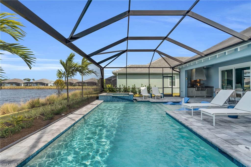 8795 Calypso Court Naples, FL 34113 - Photo 33 of 49 a view of a swimming pool with a patio