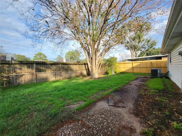 a view of a lake with a big yard and large tree