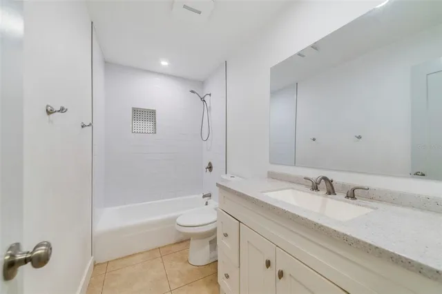a bathroom with a granite countertop sink a toilet and shower