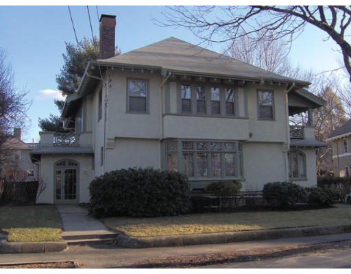 24 Evans Road Brookline, MA 02445 - Photo 2 of 7 a view of a white house with large windows and a small yard