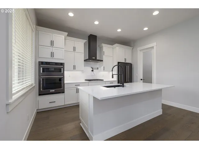 a kitchen with stainless steel appliances a stove a sink and a microwave
