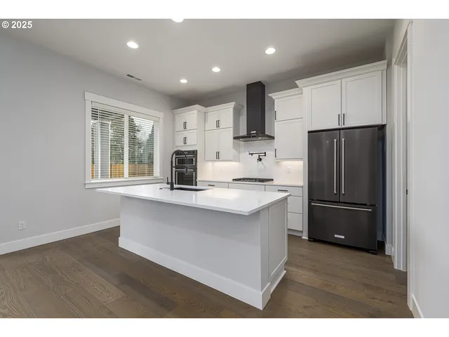 a kitchen with stainless steel appliances a refrigerator sink and microwave