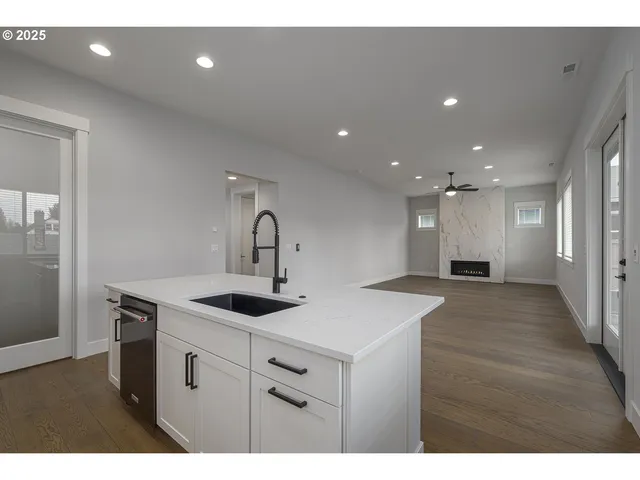 a view of a kitchen island a sink and dishwasher with wooden floor