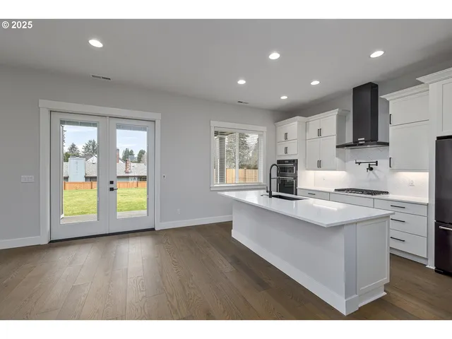 a kitchen with kitchen island a sink stainless steel appliances and cabinets