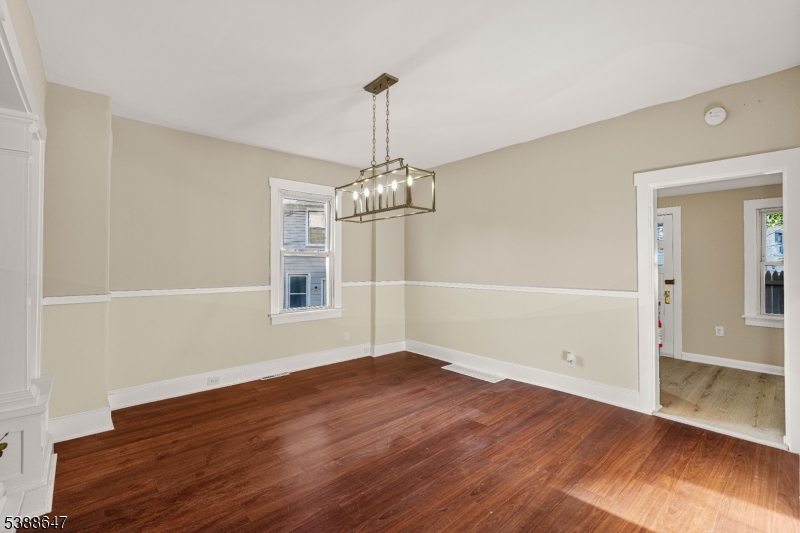 330 Chambers Street Phillipsburg, NJ 08865 - Photo 10 of 27 an empty room with wooden floor chandelier and windows