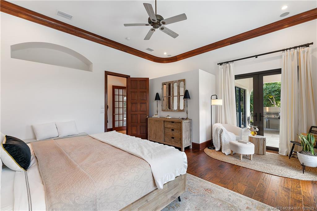 15 Middle Road Sewall's Point, FL 34996 - Photo 36 of 61 a spacious bedroom with a bed a ceiling fan and a large window