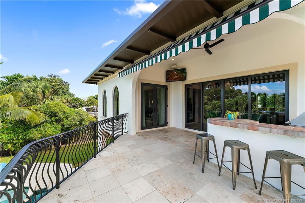 15 Middle Road Sewall's Point, FL 34996 - Photo 41 of 61 a view of a patio with table and chairs with wooden floor and fence