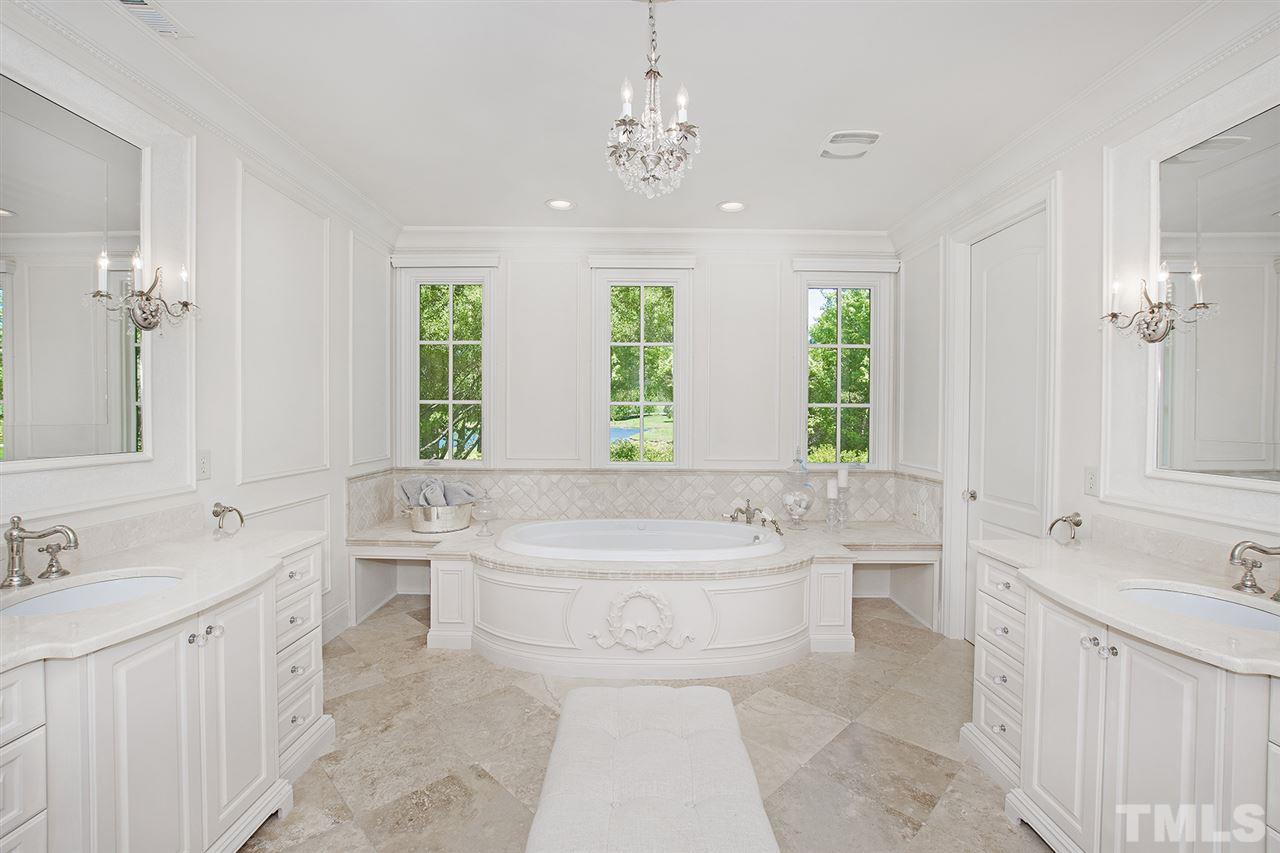 1016 Heydon Court Raleigh, NC 27614 - Photo 21 of 30 a spacious bathroom with a double vanity sink a large mirror a bathtub and next to a window