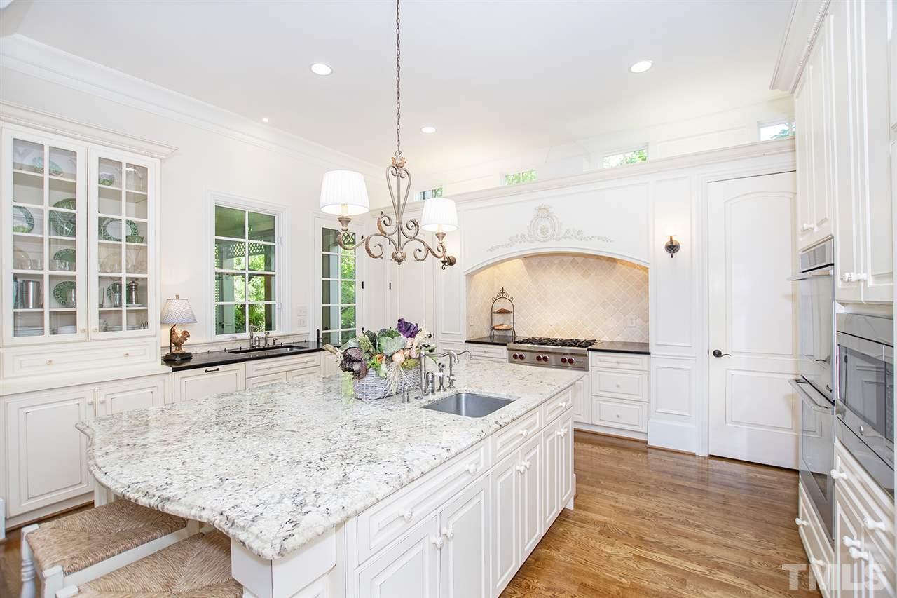 1016 Heydon Court Raleigh, NC 27614 - Photo 6 of 30 a large kitchen with kitchen island a large counter space a sink stainless steel appliances and cabinets