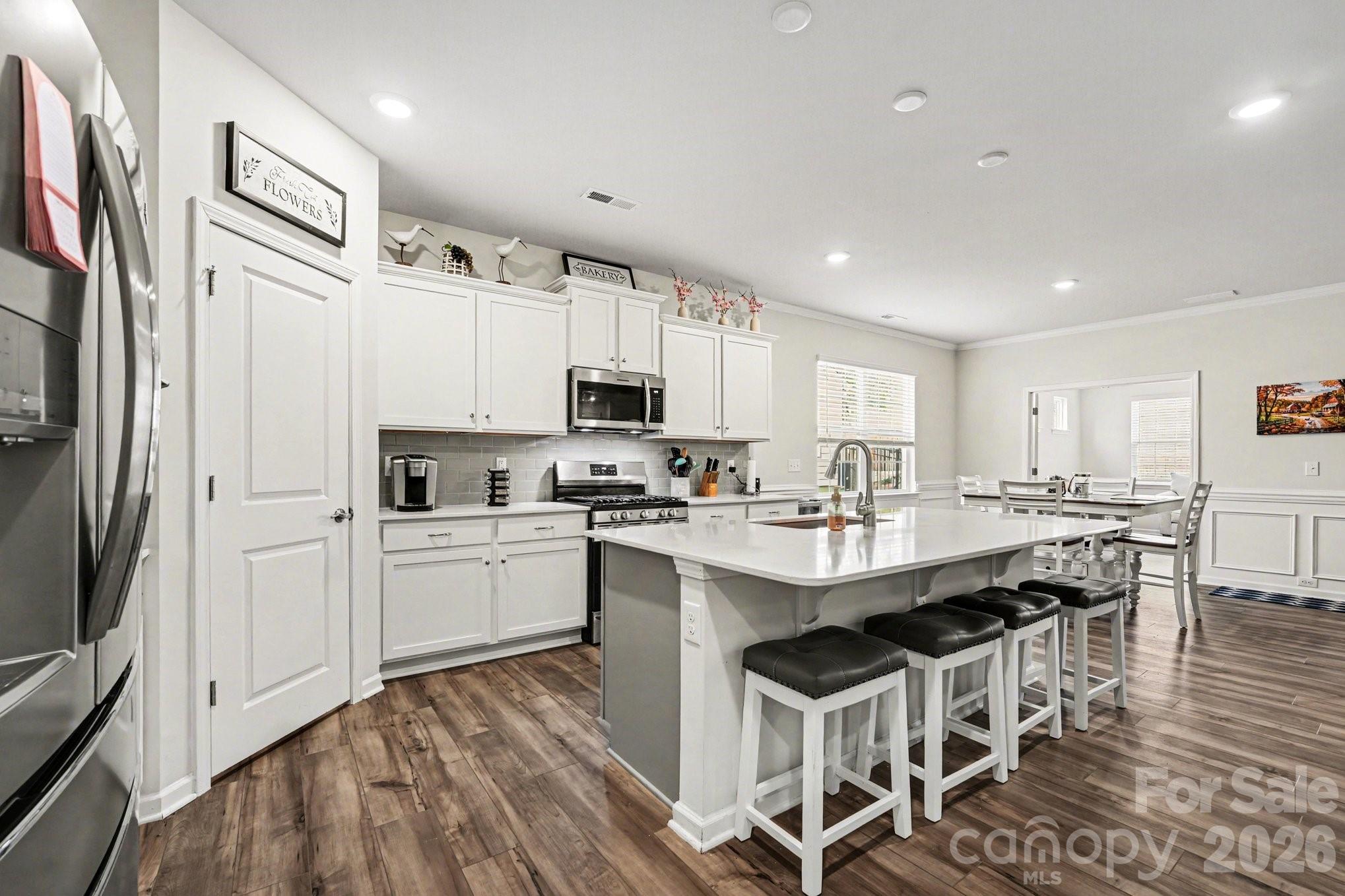 a kitchen with white cabinets and stainless steel appliances